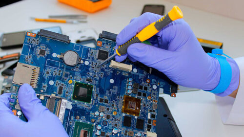 İzmir'de en iyi laptop anakart tamiri hizmetini sunan teknisyen, arızalı anakart üzerinde hassas onarım işlemi yapıyor.